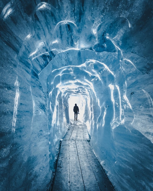 Foto vista posteriore di una persona in piedi in una grotta di neve