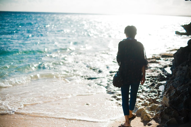 rear view of person walking on beach