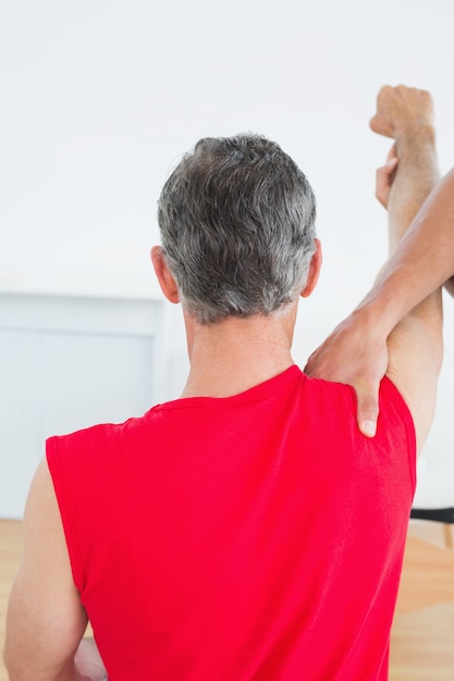 Foto retrovisione di un fisioterapista che massaggia il braccio dell'uomo maturo