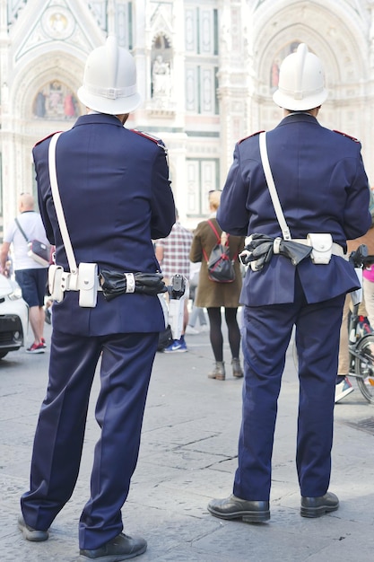 Photo rear view of police force standing on street