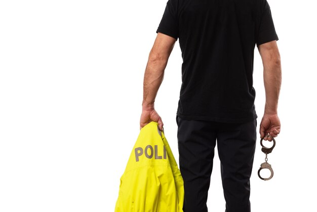 Foto vista posteriore di un poliziotto con l'uniforme in mano e le manette ufficiale carcerario sicurezza della polizia in carcere