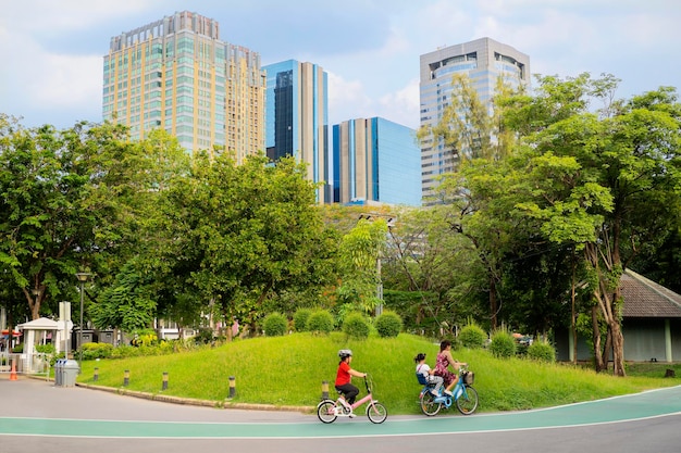 Rear view portrait of mother and daughter riding bicycles in park