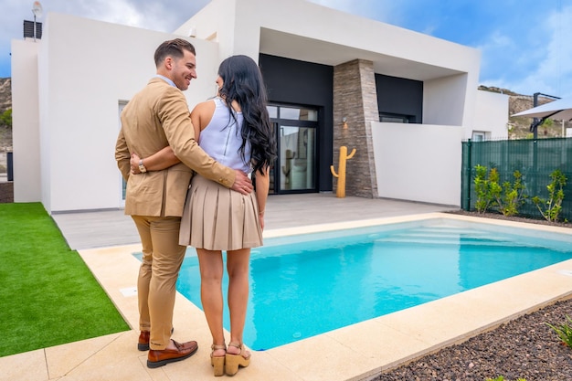 rear view of a proud couple contemplating their newly bought home