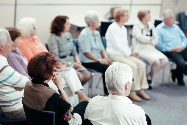 Rear view of a senior people listening a lecture