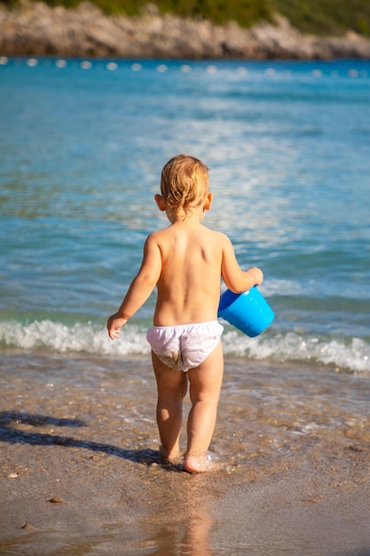 Photo rear view of shirtless boy on beach