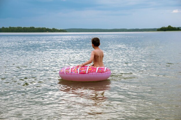 Rear view of shirtless boy in lake
