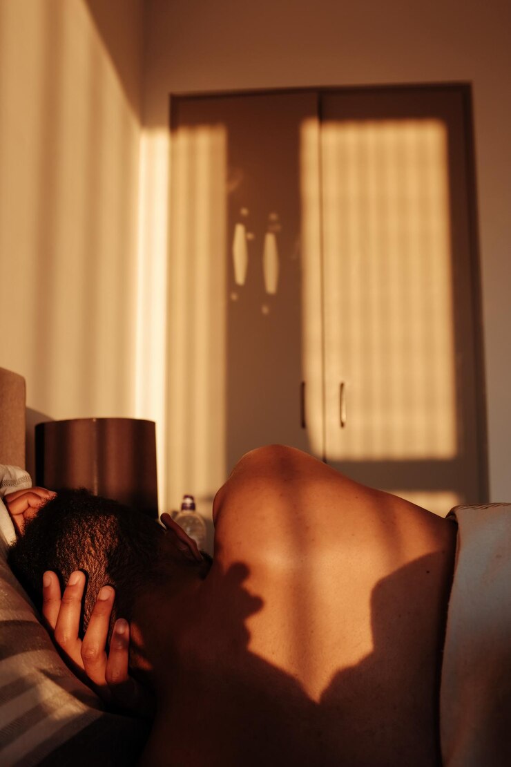Photo rear view of shirtless man sleeping on bed during sunny day
