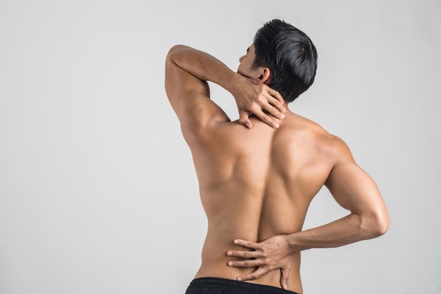 Vista posteriore di un uomo senza camicia che soffre di mal di schiena sullo sfondo bianco