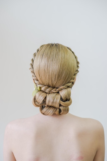 Rear view of shirtless woman with hairstyle against white background