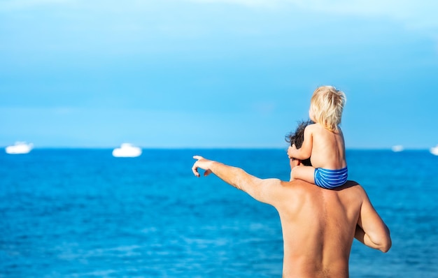 Rear view of shirtless young woman in sea against sky