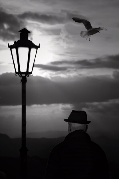 Foto vista posteriore di un uomo in silhouette in piedi contro il cielo durante il tramonto