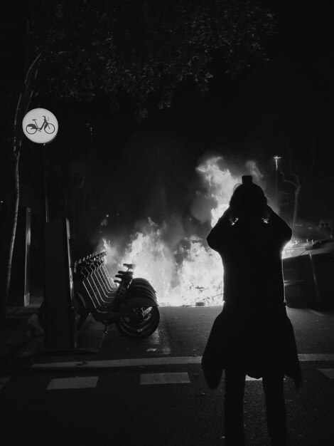 Foto vista posteriore di un uomo a silhouette in piedi per strada durante una rivolta