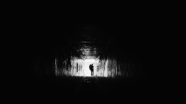 Photo rear view of silhouette man walking in tunnel