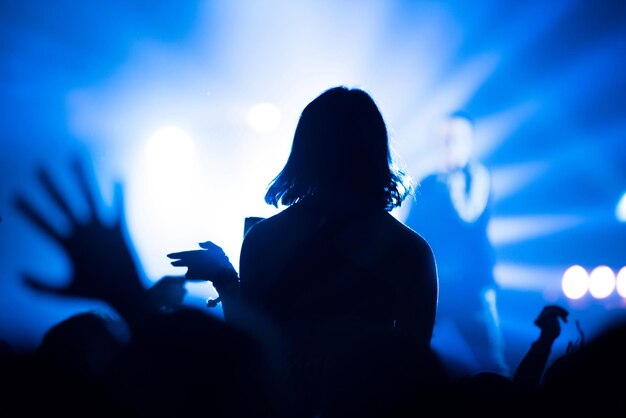 Photo rear view of silhouette woman at music concert