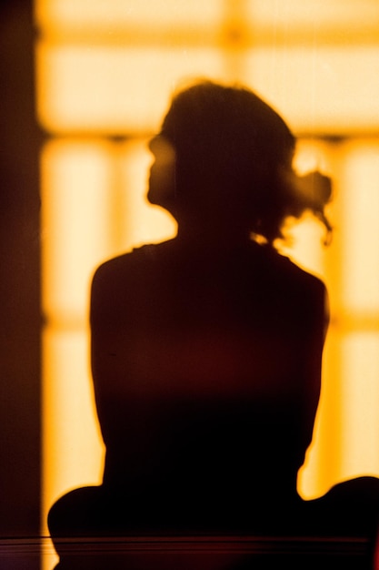 Photo rear view of silhouette woman standing against wall