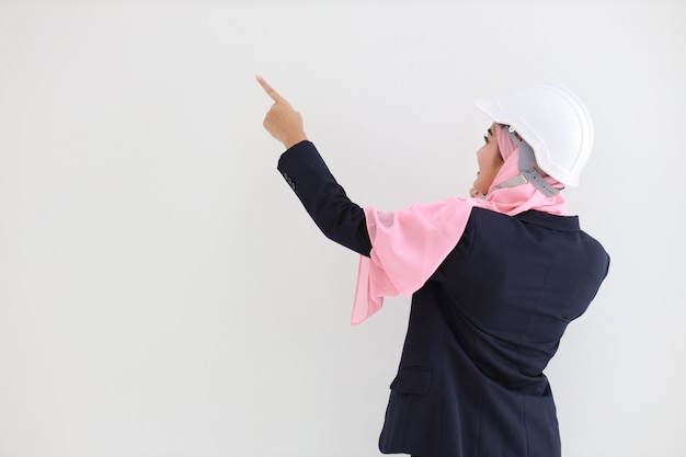 Rear view smart engineering muslim young asian woman wearing blue suit with confident, pointing and using mobile phone