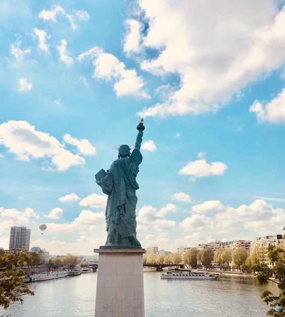 Foto vista posteriore della statua della libertà sulla senna contro il cielo nuvoloso a parigi