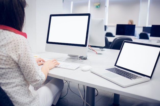 Rear view of student using computer at university 