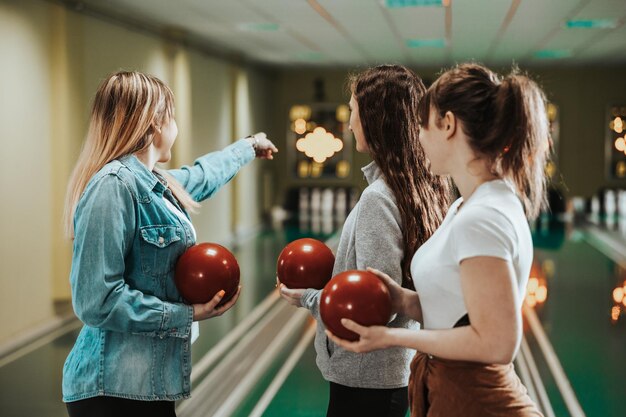 Retrovisione di tre amici della giovane donna al bowling.