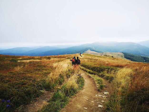 Photo rear view of trail on landscape against sky