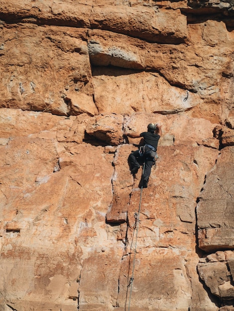 Rear view of an unrecognizable male rock climber climbing a difficult route on a rock in siurana el