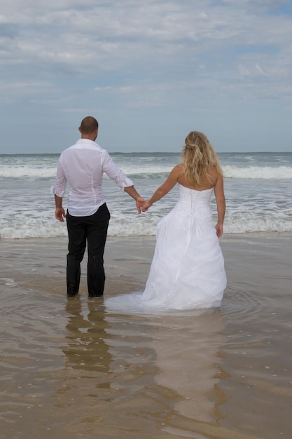 ビーチでの背面図の結婚式のカップル