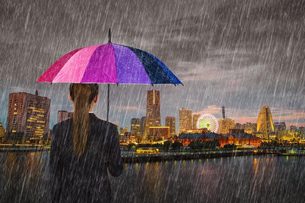 Rear view of wet umbrella against sky during rainy season