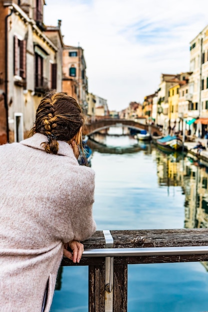 Photo rear view of woman against canal in city