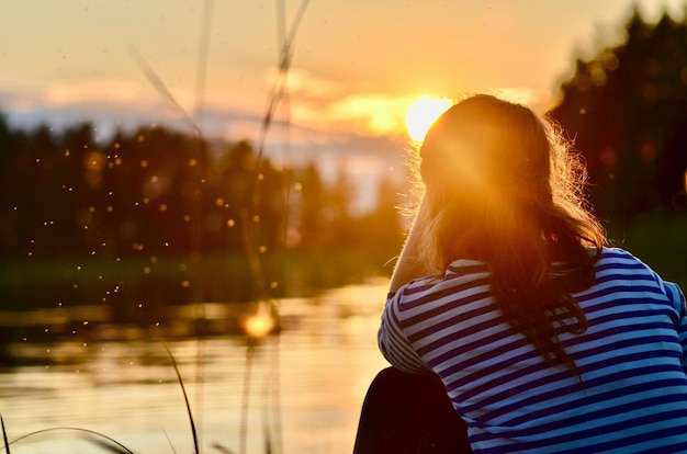 Foto vista posteriore di una donna contro il cielo durante il tramonto