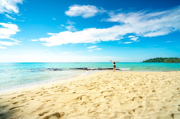 Rear view of woman at beach against sky