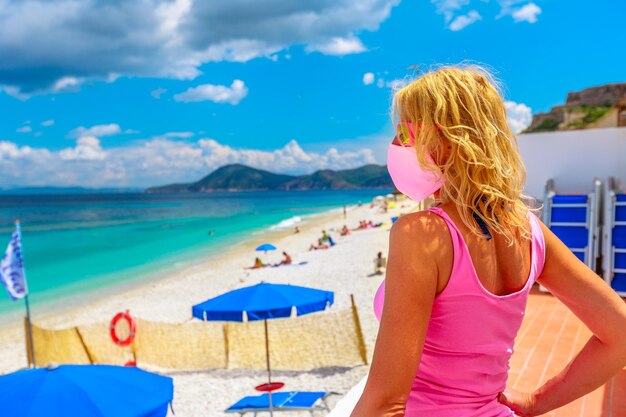 Rear view of woman at beach against sky