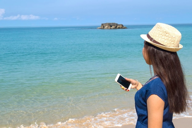 Rear view of woman on beach against sky