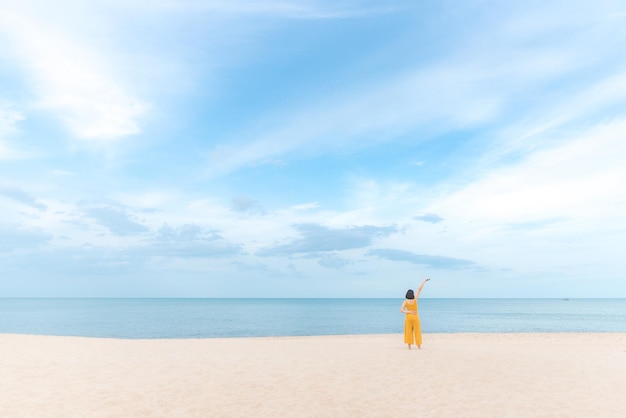 空の向こうのビーチの女性の後ろの景色