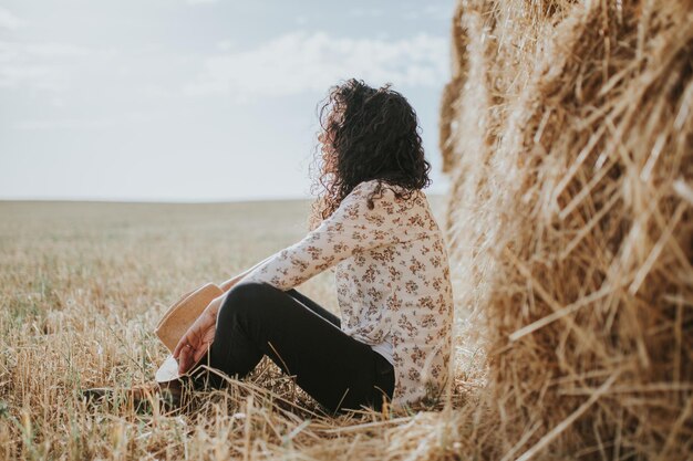 Foto vista posteriore di una donna da una pala di fieno