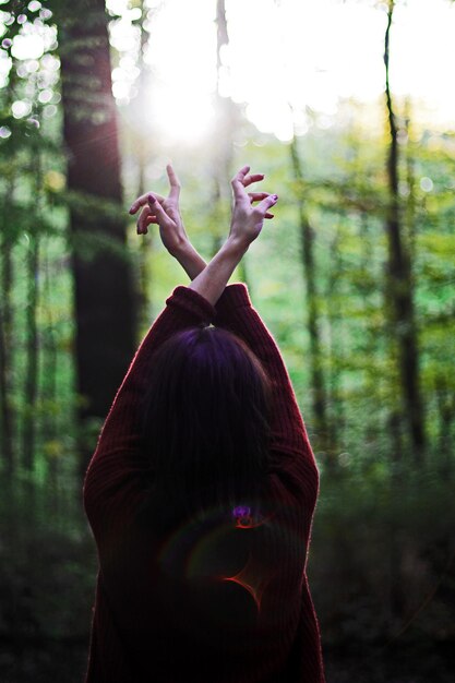 Foto vista posteriore di una donna che balla nella foresta