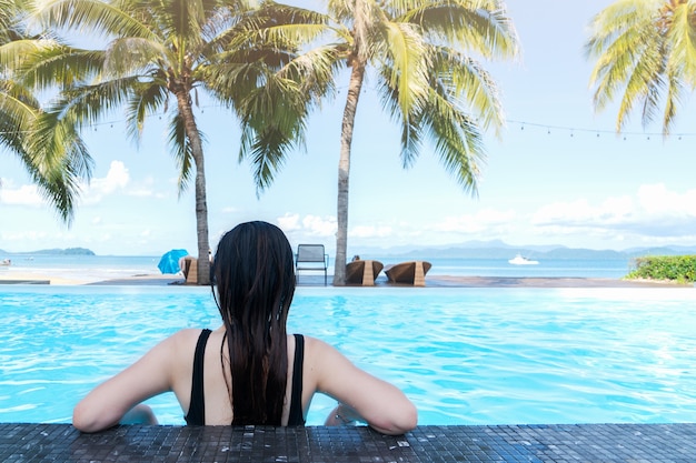 Rear view of woman enjoying the swimming pool