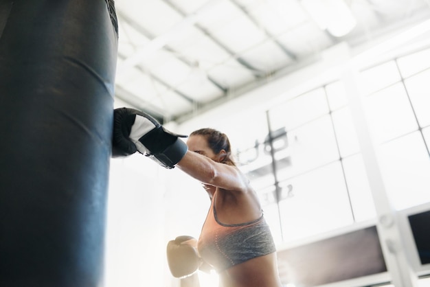 Photo rear view of woman exercising in gym