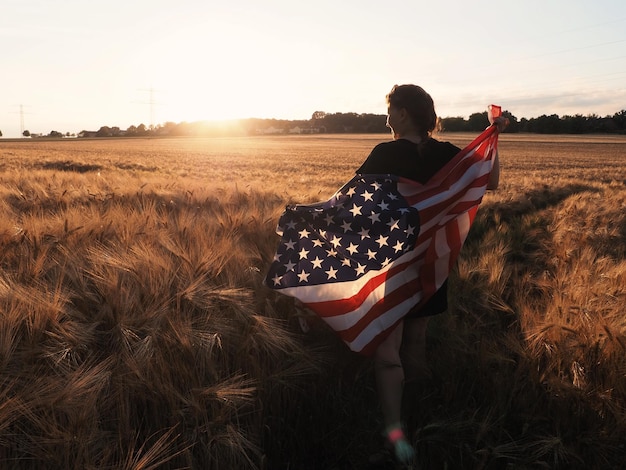 Photo rear view of woman on field against sky during sunset