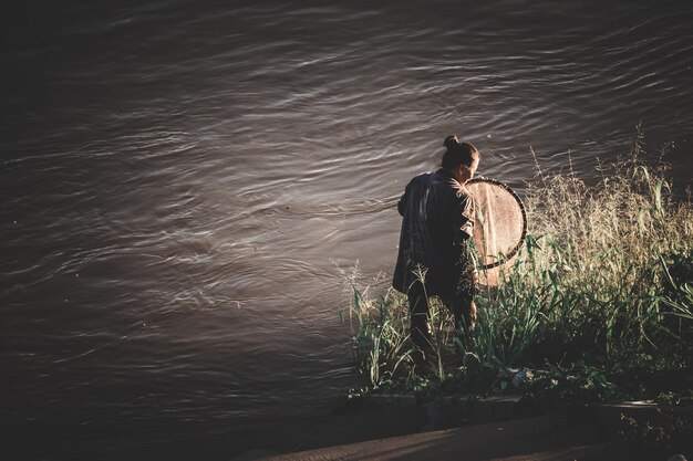 湖で釣りをしている女性の後ろの景色