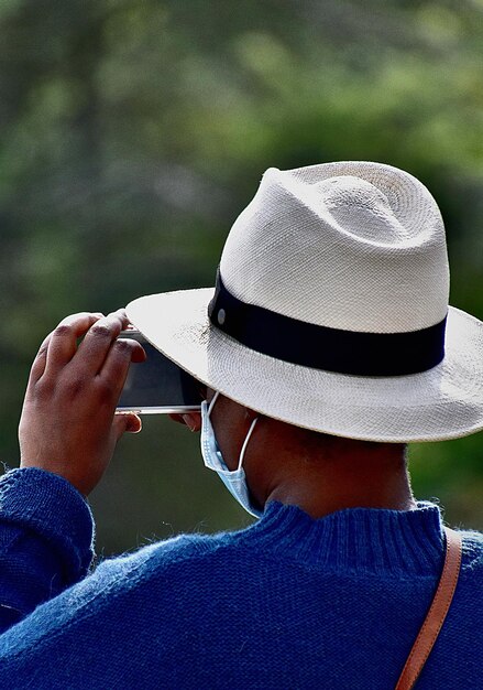 Photo rear view of woman holding hat