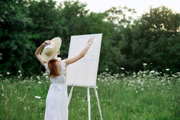 Rear view of woman holding umbrella on field