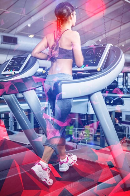 Rear view of woman jogging in treadmill at gym