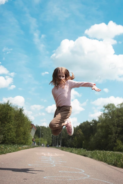 Photo rear view of woman jumping on road against sky