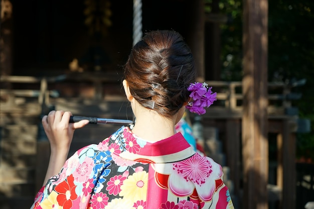 Foto vista posteriore di una donna in kimono in piedi all'aperto