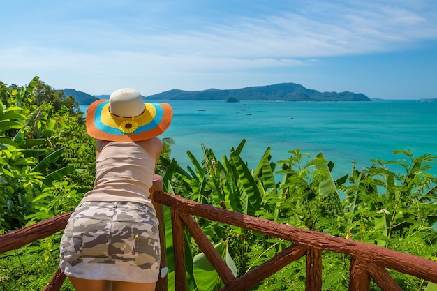 Photo rear view of woman leaning on railing by sea against sky