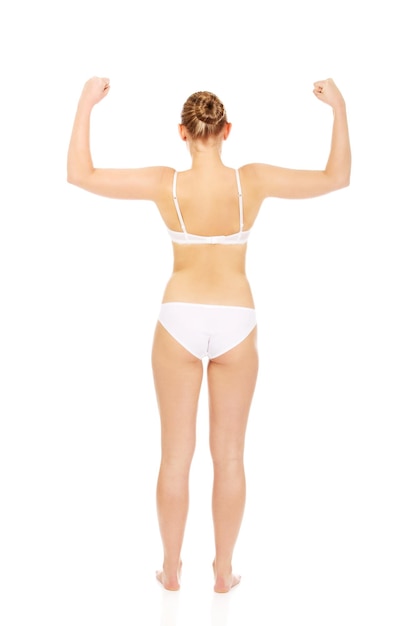 Rear view of woman in lingerie flexing muscles against white background