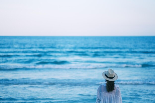 Photo rear view of woman looking away while standing by sea