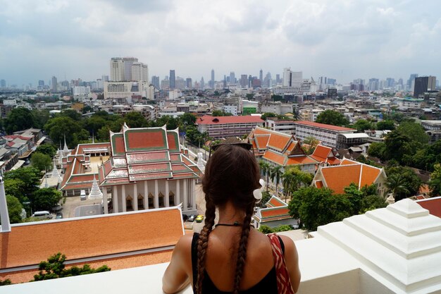 Rear view of woman looking at buildings in city