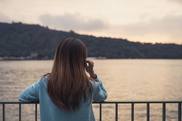 Photo rear view of woman looking at lake in forest