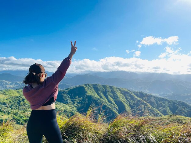 Rear view of woman looking at mountain against sky